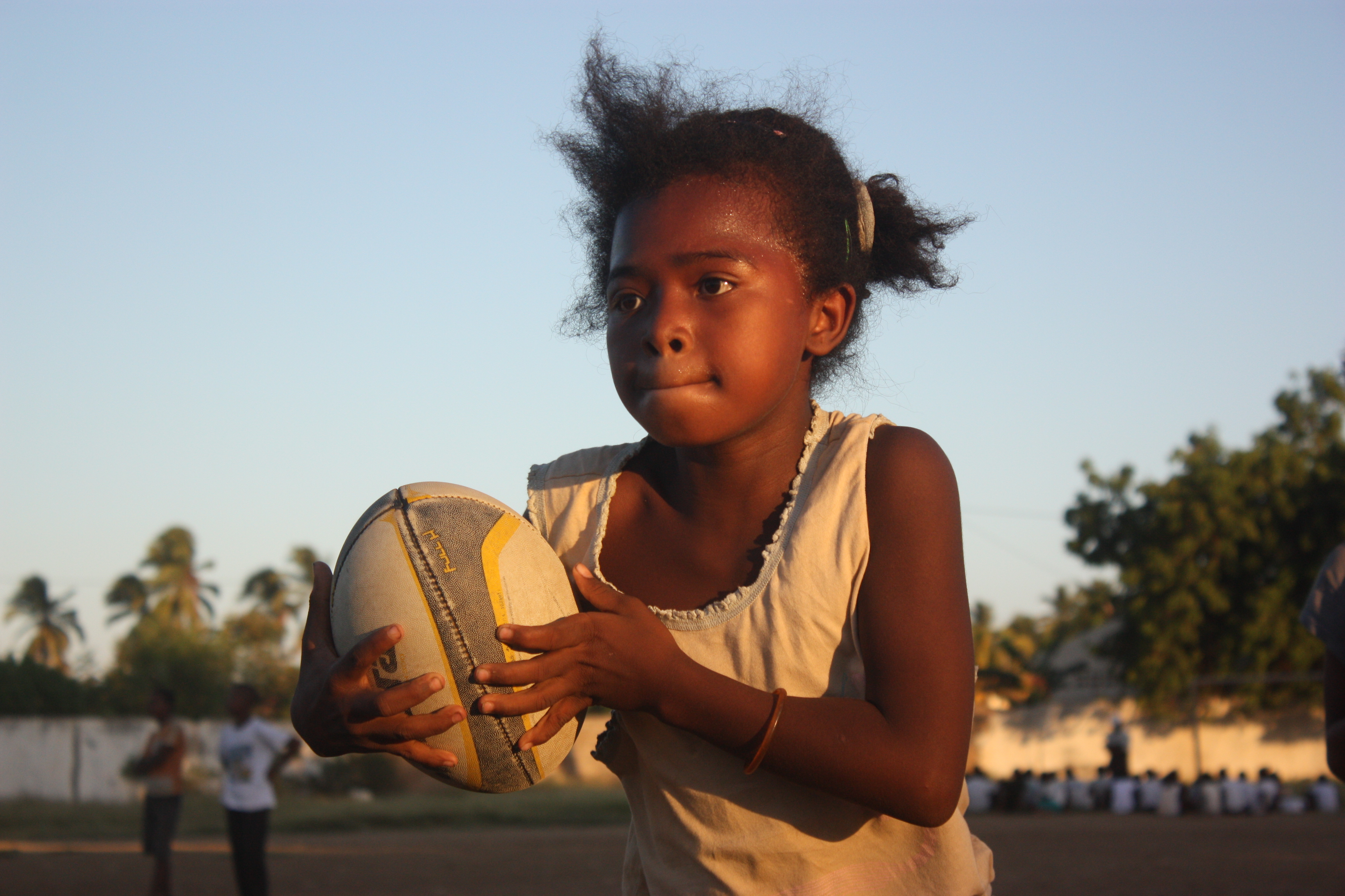 Petite fille tient un ballon de rugby